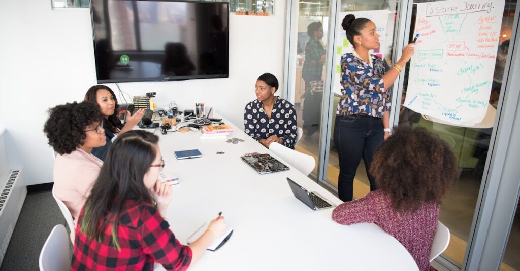A multicultural office team engages in a collaborative brainstorming session around a conference table.